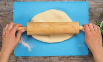 Plaats de vulling in het midden van alle deegcirkels. We wikkelen het in deeg, vormen een platte cake, draaien de naad naar beneden en rollen hem voorzichtig uit.