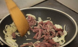Leg het vlees op de ui en bak al roerend 5-7 minuten.