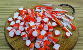 Nadat je de krabsticks uit de schaal hebt bevrijd, snijd je er drie in driehoeken en snijd je de overige in cirkels.