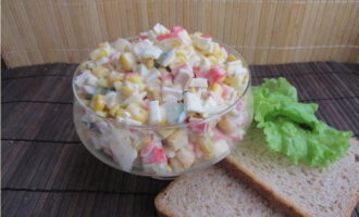 De klassieke salade met krabsticks, maïs, ei en komkommer is klaar! Verdeel over serveerschalen en serveer. Kook en heb plezier!