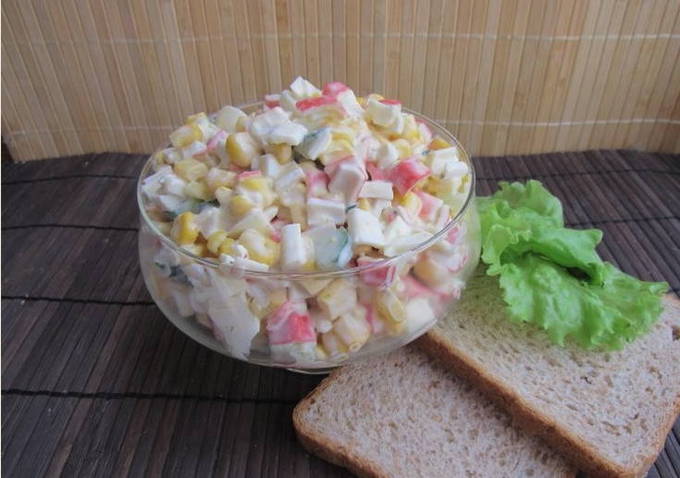 Klassieke salade met krabsticks, maïs, ei en komkommer