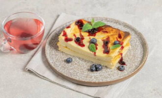 Kwarkschotel in de oven, net als op de kleuterschool, klaar! Koel het hete product af. Snijd en serveer in porties, voeg siroop, jam of gecondenseerde melk toe. Versier eventueel met muntblaadjes en verse bessen. Wij serveren extra drankjes. Eet smakelijk!